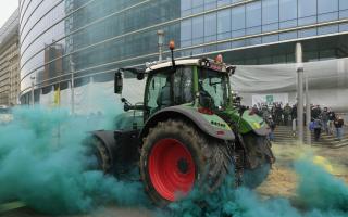 A farmer drives his tractor near the European Council building in Brussels during a demonstration of farmers, Tuesday, March 26, 2024. Dozens of tractors sealed off streets close to European Union headquarters where the 27 EU farm ministers are meeting
